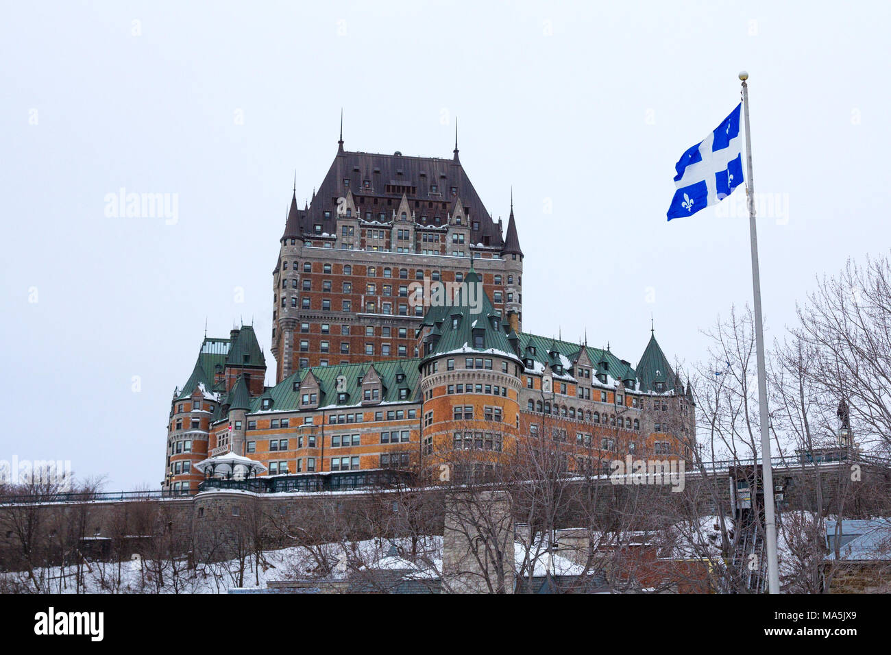 Vista di Frontenac (Castel de Chateau Frontenac, in francese) in inverno sotto la neve con una bandiera del Quebec rinuncia a. Lo Château Frontenac è un grand hotel Foto Stock