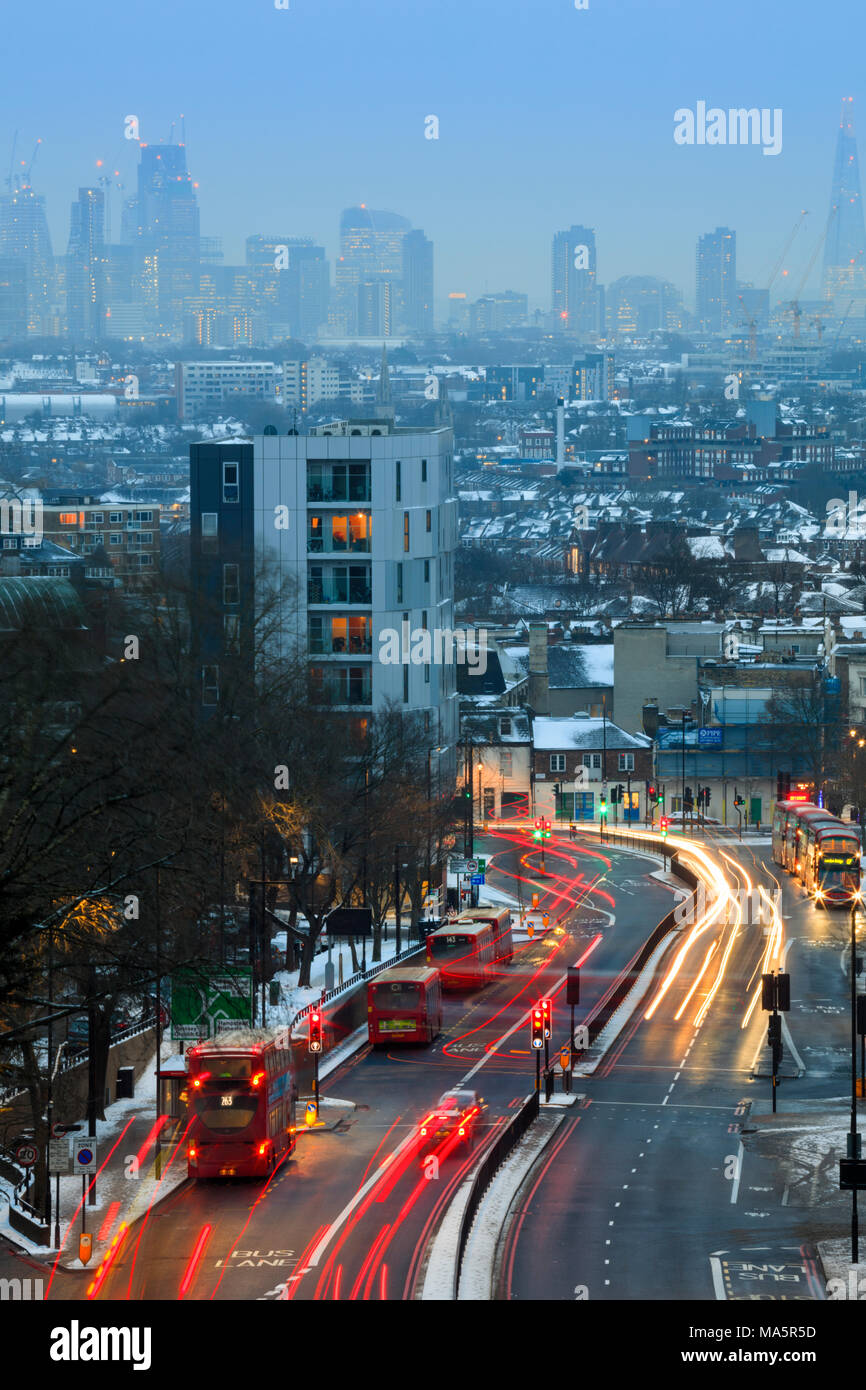 Skyline del centro finanziario di Londra, traffico in movimento sull'autostrada trafficata, vista invernale con neve, senza persone, Archway, Londra del nord, Londra, Regno Unito Foto Stock