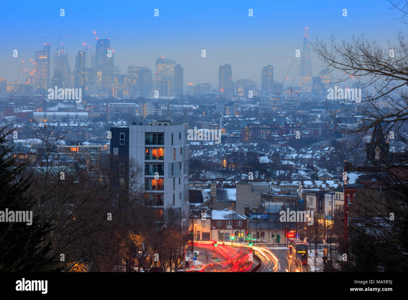 Skyline del centro finanziario di Londra, traffico in movimento sull'autostrada trafficata, vista invernale con neve, senza persone, Archway, Londra del nord, Londra, Regno Unito Foto Stock