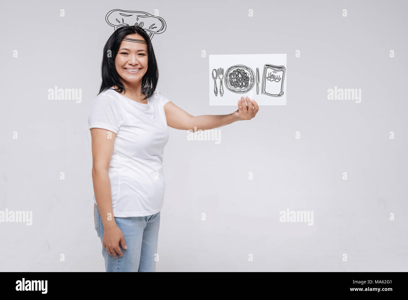 Bravo giovane donna sogna di diventare un cuoco e sorridente Foto Stock