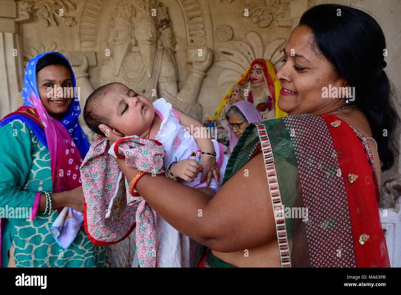 Una bambina con la nonna e la madre essendo beato in un tempio indù Mandore Gardens jodhpur Rajashan india Foto Stock