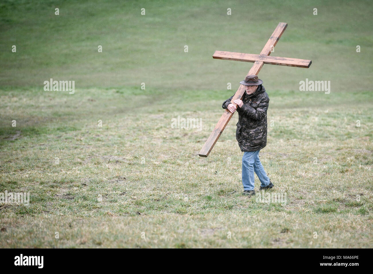 Una croce di legno è portato fino Roundhill in bagno, Wiltshire, dove molti cristiani della Chiesa le congregazioni prendere parte nel cammino di testimonianza di imitare il cammino che Gesù ha preso portando la sua croce attraverso le strade di Gerusalemme nel giorno di Venerdì Santo. Foto Stock