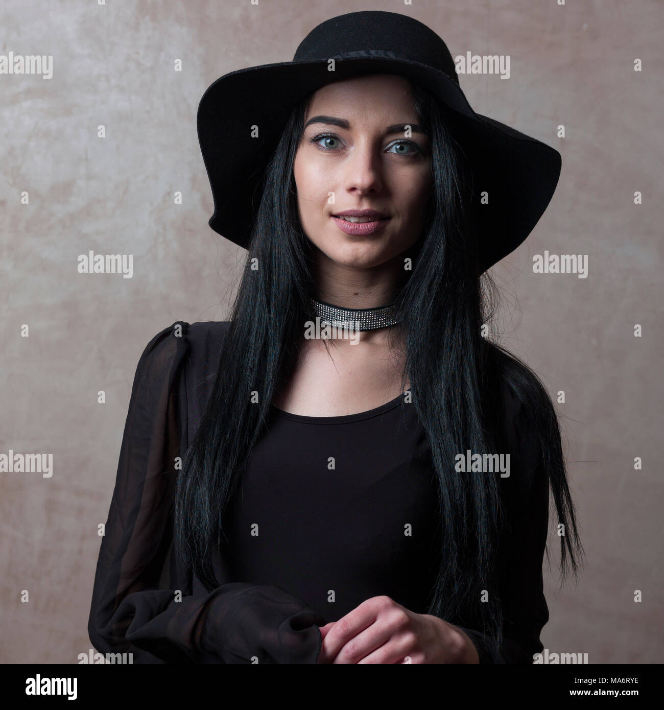 Affascinante ragazza di accoppiamento tra cappello nero e nero elegante top guarda malinconica - testa e spalle - hobo fashion Foto Stock