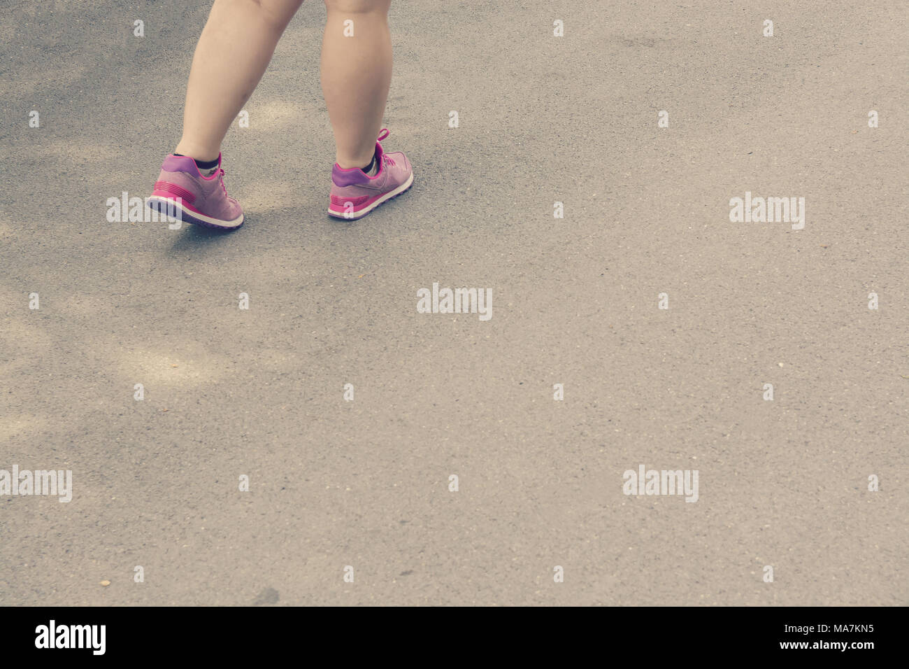 Grasso donna gambe camminando in calzature sportive Foto Stock