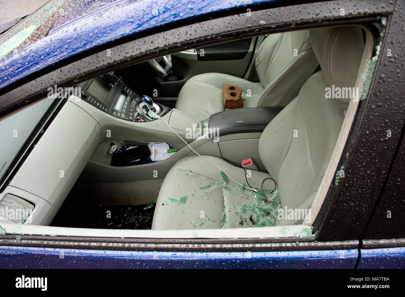 Una vettura rotto recentemente in con mattone incriminato visibile sul sedile di guida - parcheggiata su una strada di Londra Foto Stock
