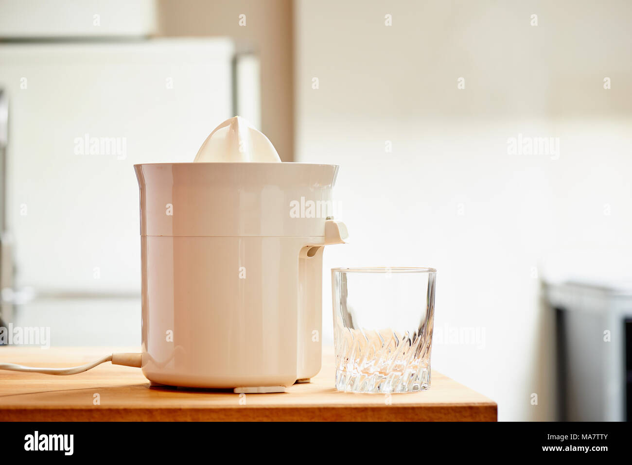 Spremiagrumi elettrico e vuoto di vetro in una cucina moderna Foto Stock