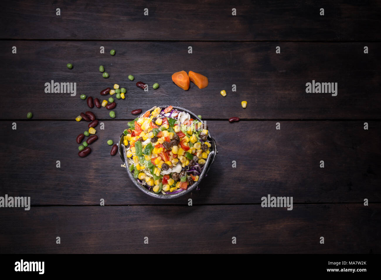 Insalata fresca con mais e miscelati su sfondo di legno vista dall'alto. Cibo sano. Foto Stock