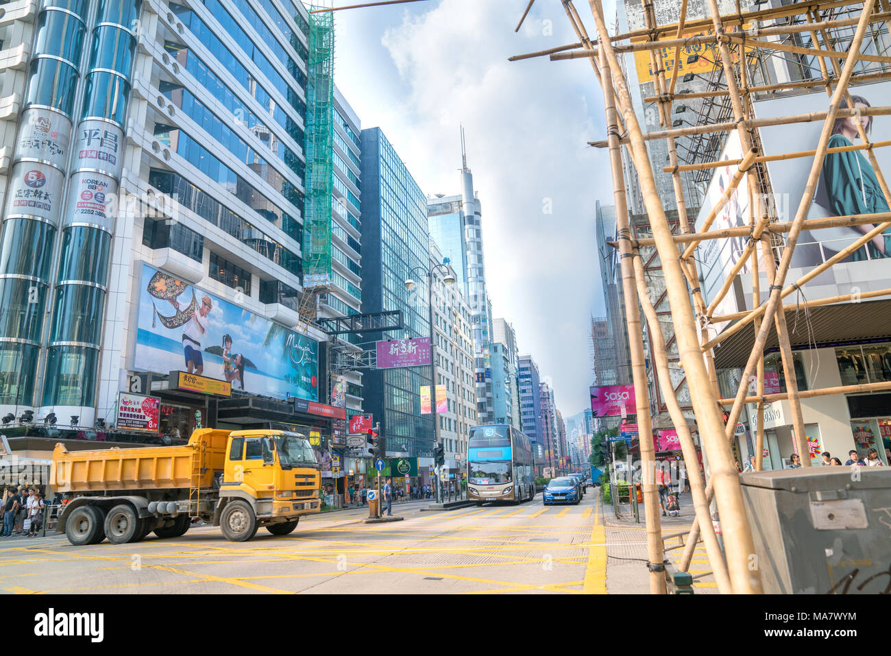 KOWLOON, HONG KONG - 18 settembre 2017; tipicamente Asian downtown city street scene con moderni edifici su un lato impalcature di bambù attraverso street Foto Stock