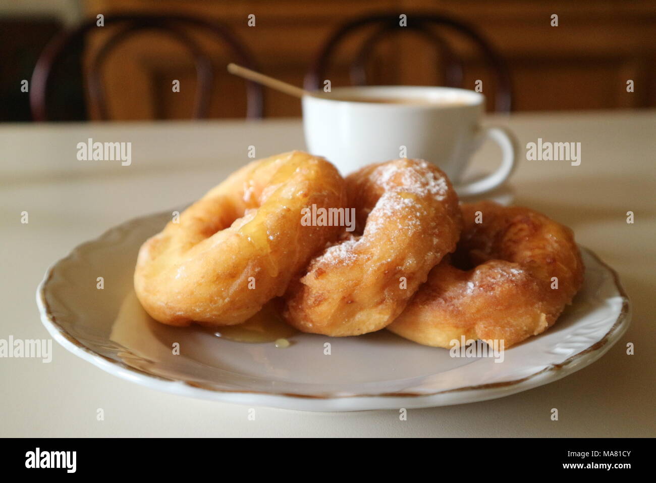 Ciambelle fritte con il miele e il caffè sul tavolo Foto Stock