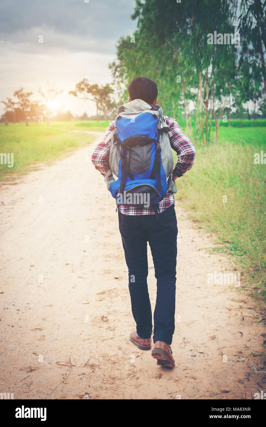 Chiudere i giovani hipster uomo con zaino in spalla passeggiando per le  campagne Foto stock - Alamy