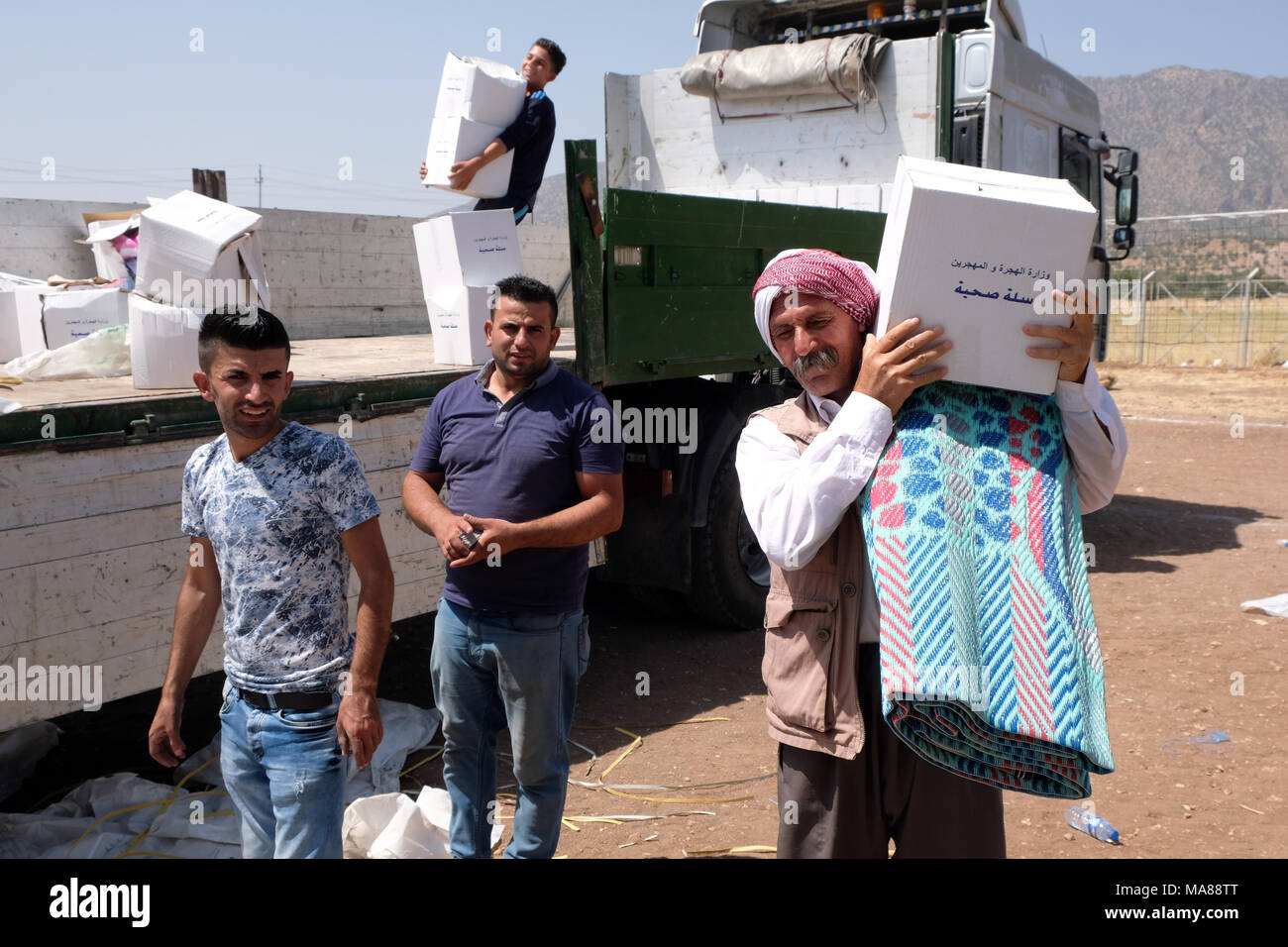 Nell Iraq del nord, Curdo Regione Autonoma: di forniture di soccorso sono distribuiti nel Dawidiya Camp per Yezidi sfollati dalla Montagne Sinjar Foto Stock