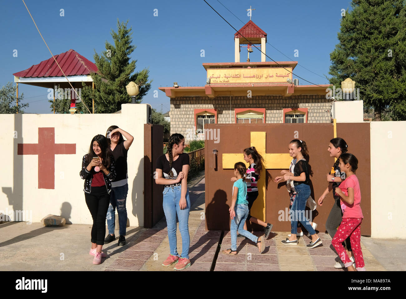 I giovani di fronte alla chiesa Caldean Oraha Mor in Levo, nell Iraq del Nord, regione del Kurdistan in Iraq Foto Stock