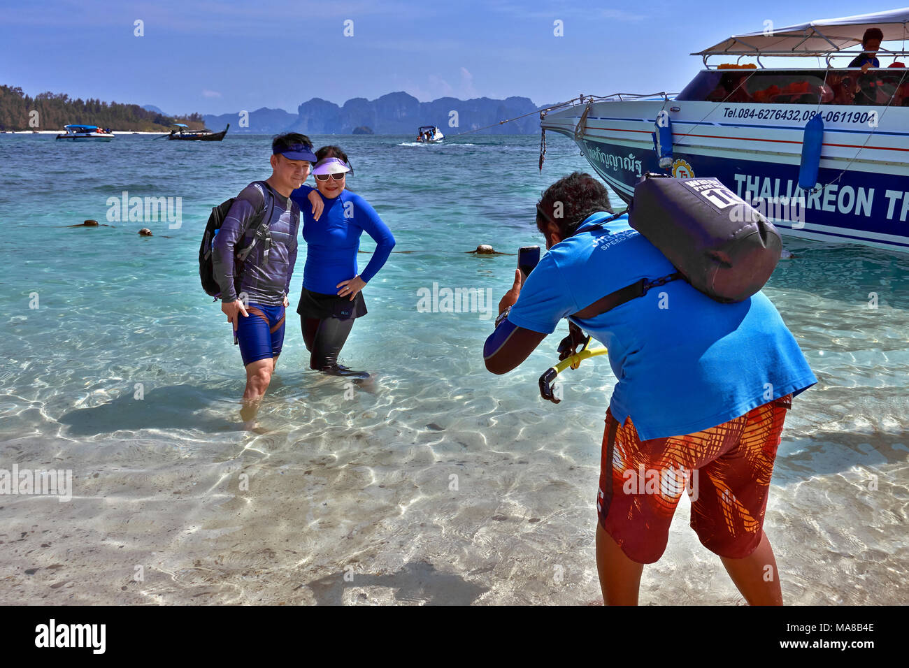 Uomo che usa smartphone per fotografare i turisti a Thale Waek isola Krabi Thailandia Sud-Est asiatico Foto Stock