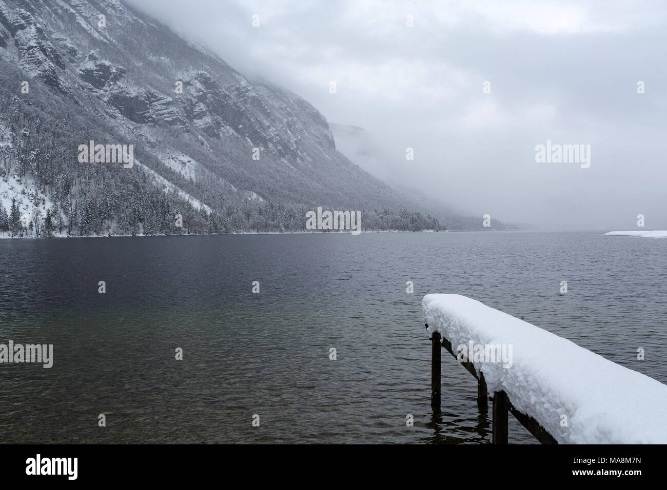 Poco pier coperte di neve sulle sponde di un lago in una fredda giornata invernale Foto Stock