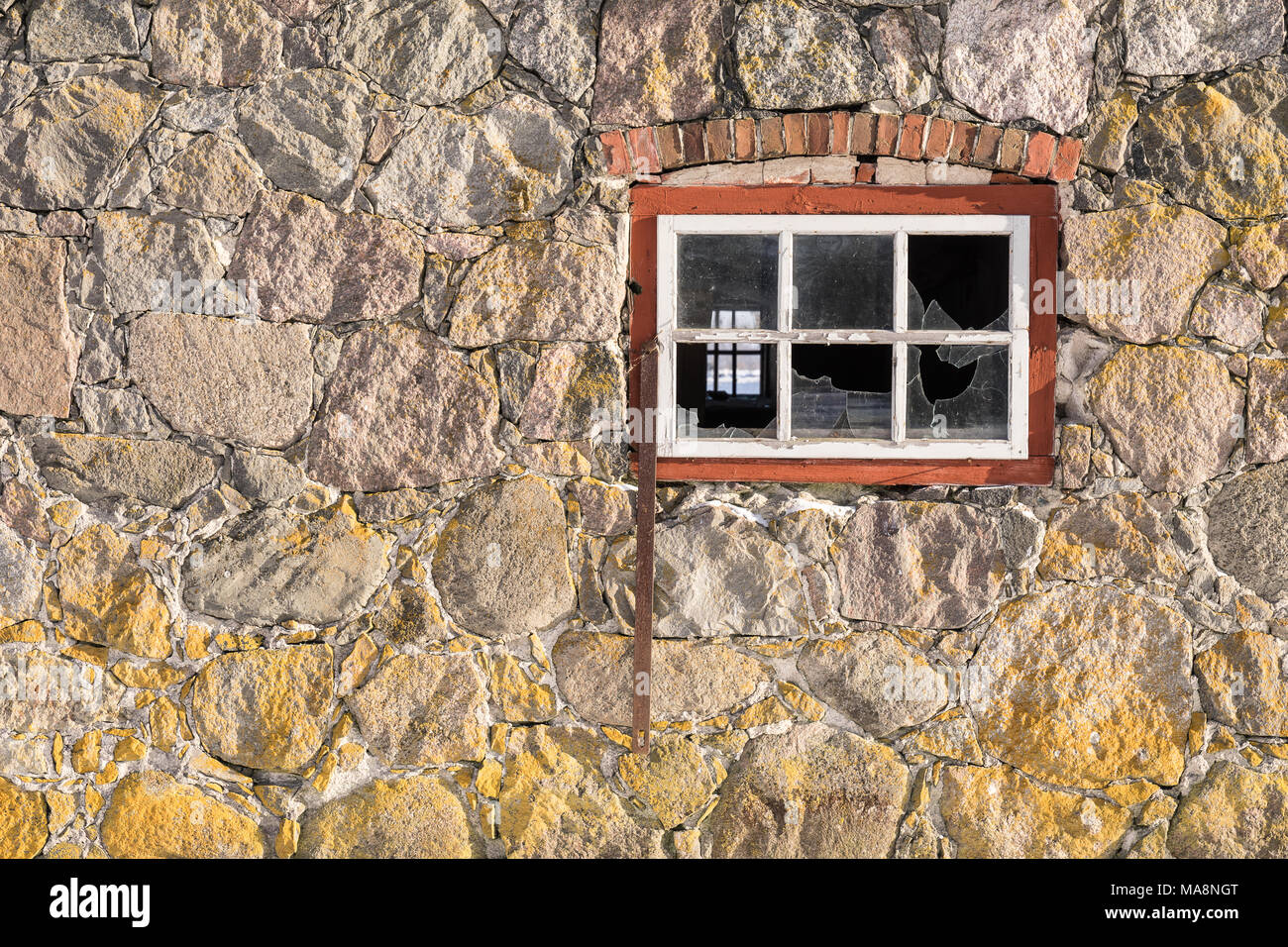 Muro di pietra di consistenza e di finestre con riquadri rossi, naturale configurazione di sfondo Foto Stock