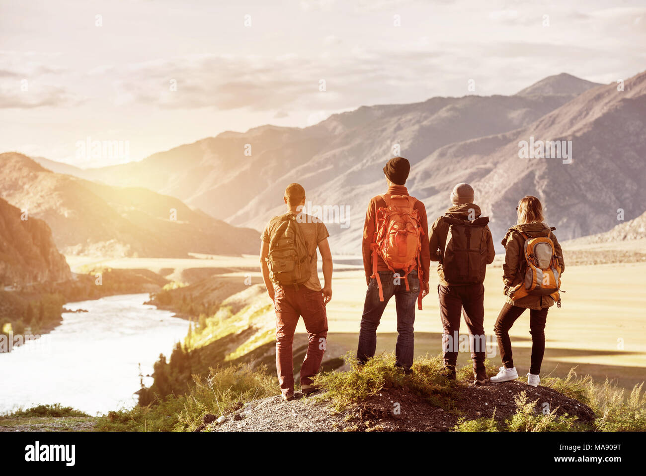 Quattro amici tramonto montagne concetto di viaggio Foto Stock