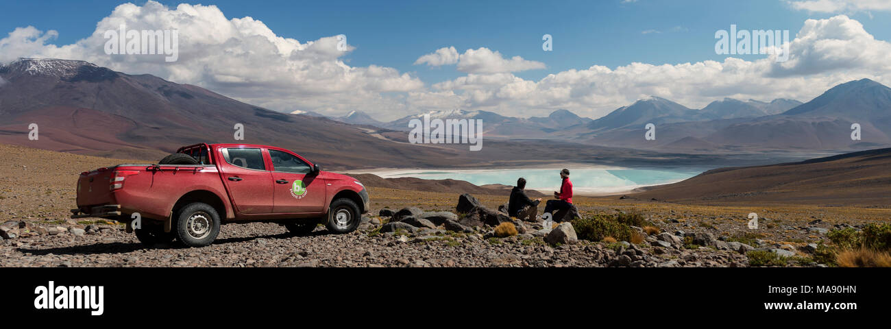 Coppia giovane i viaggiatori in un paesaggio di montagna su una 4x4 tour e camping in Sud America, godendo la vista a colazione sulla Laguna Verde da f Foto Stock