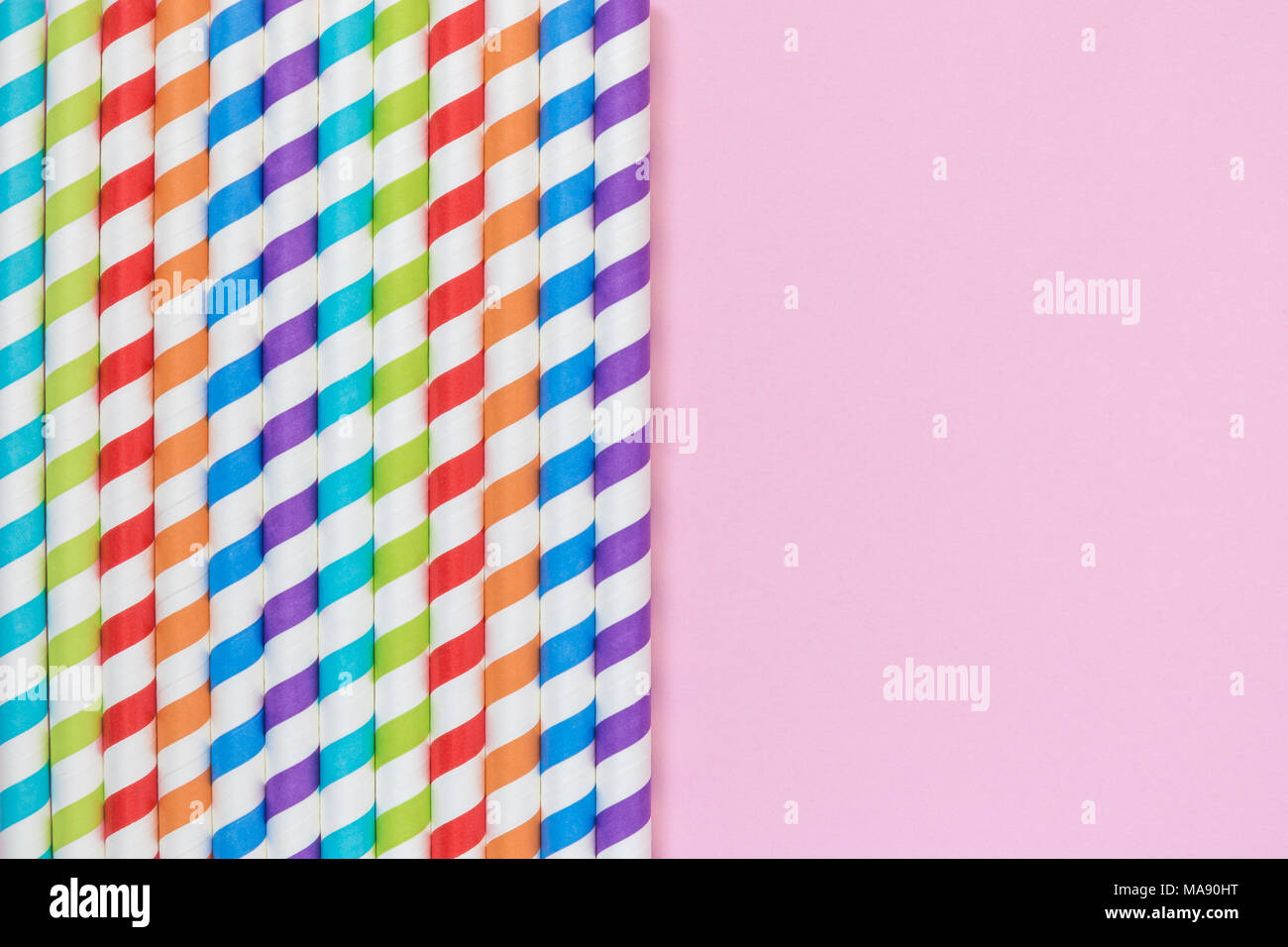 A strisce colorate di bere cannucce sul rosa pastello minima di sfondo concetto creativo. Spazio per la copia. Foto Stock