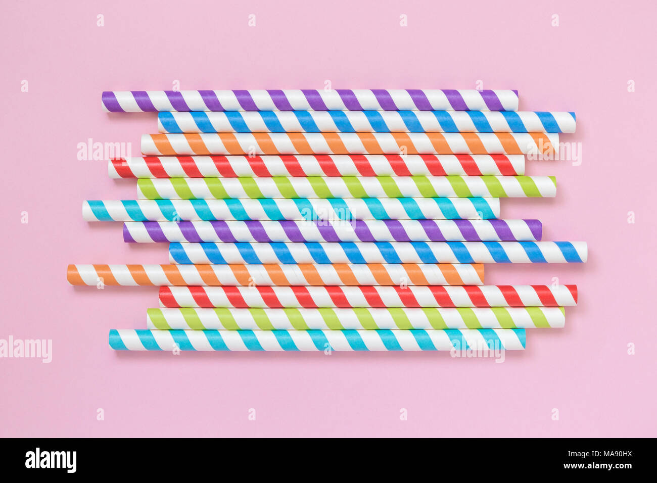 A strisce colorate di bere cannucce sul rosa pastello minima di sfondo concetto creativo. Foto Stock