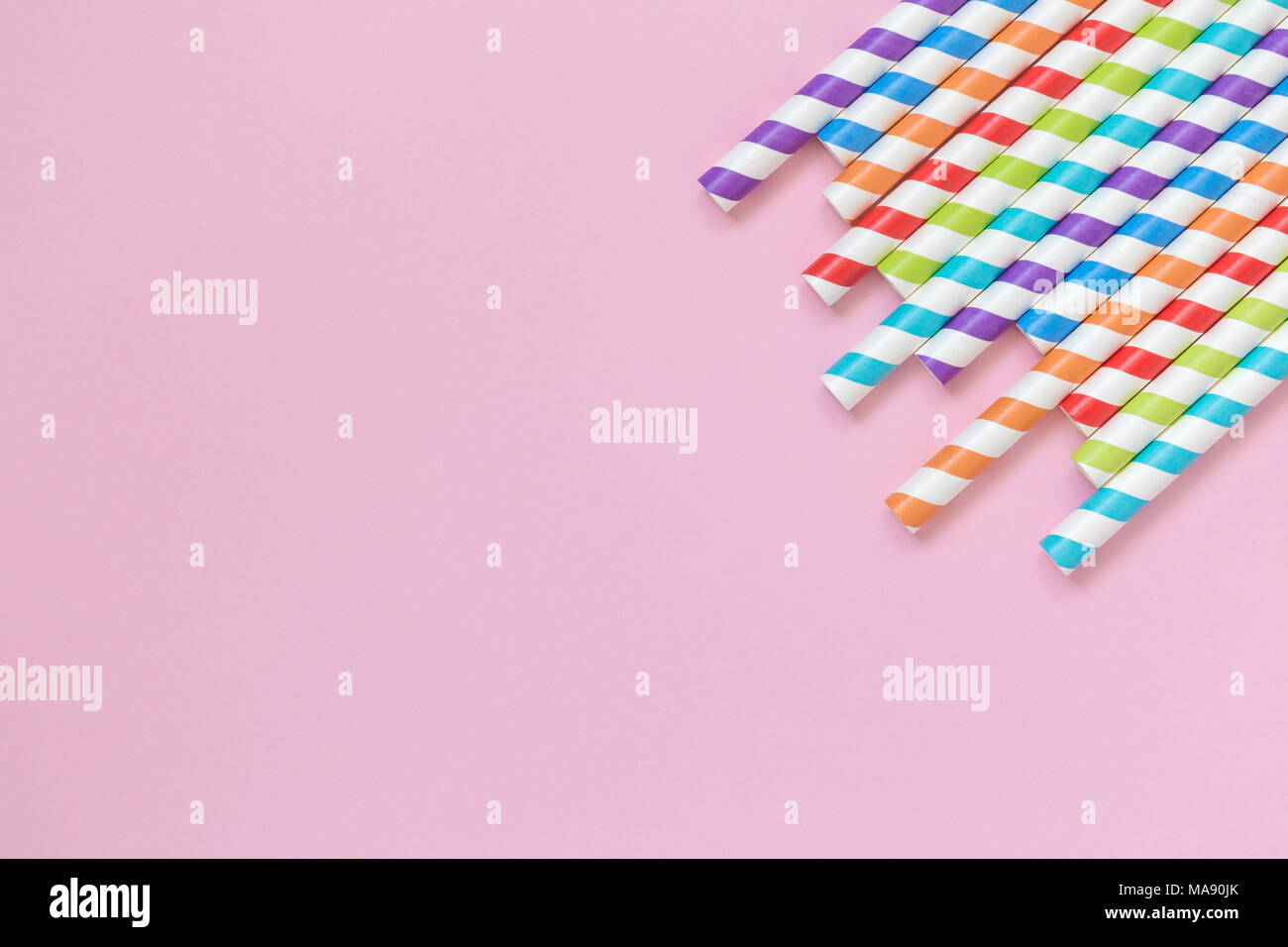 A strisce colorate di bere cannucce sul rosa pastello minima di sfondo concetto creativo. Spazio per la copia. Foto Stock