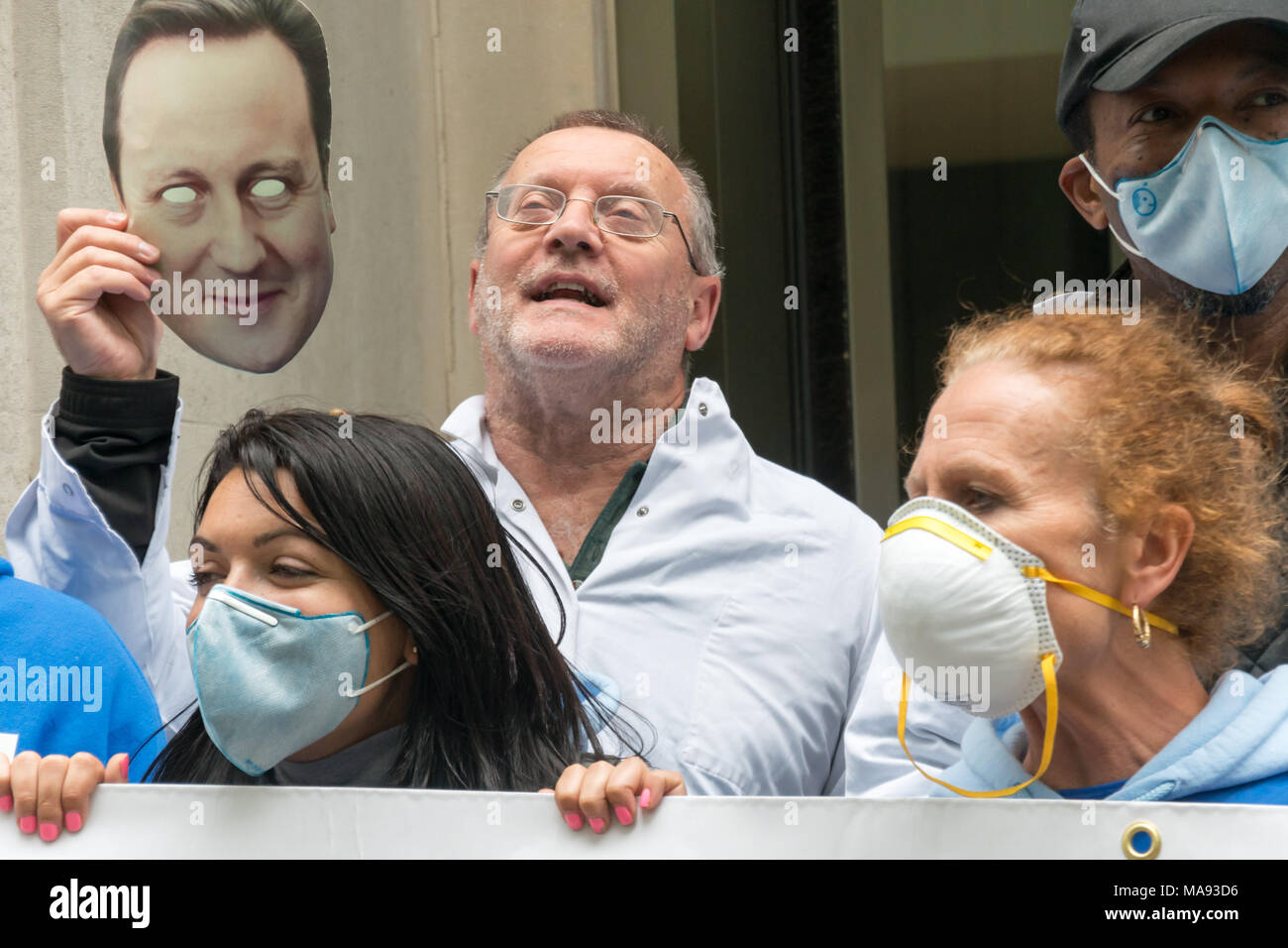Manifestanti con David Cameron maschera alla Vergine Care HQ a Londra chiamata per porre fine alla società privata utilizzando il logo di NHS e per la Vergine a smettere di elusione fiscale. Foto Stock