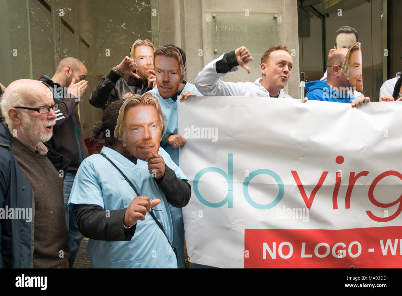 Manifestanti con Richard Branson maschere a cura di vergine HQ a Londra chiamata per porre fine alla società privata utilizzando il logo di NHS e per la Vergine a smettere di elusione fiscale. Foto Stock