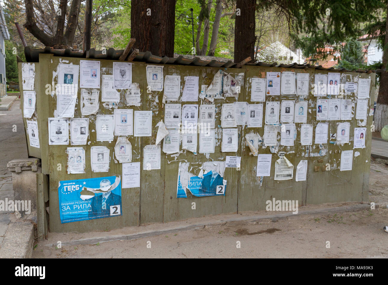 Avvisi commemorativi e/o avvisi di morte (poster o necrolos) su una bacheca nel villaggio di Rila, Bulgaria sud-occidentale. Foto Stock