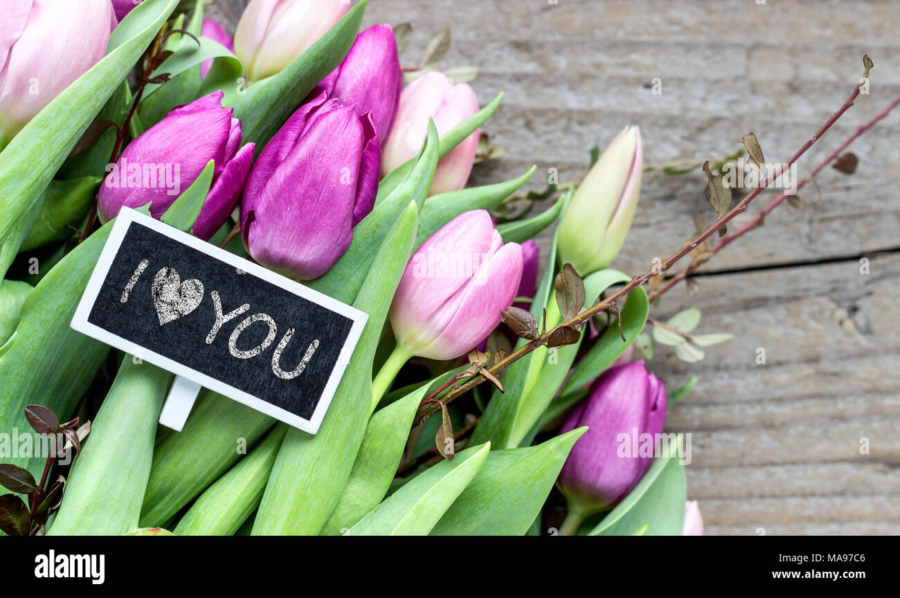 Bouquet con rosa e viola tulipani e piccola lavagna con il testo: ti amo Foto Stock