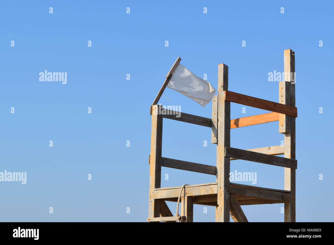 Bandiera bianca nel vento su una sedia beachguard Foto Stock