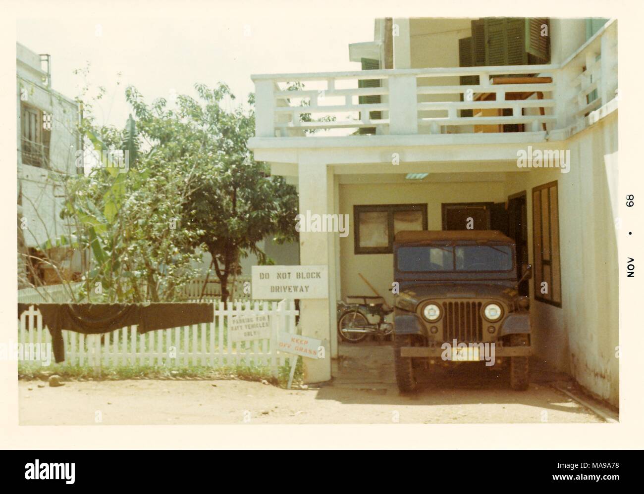 Fotografia a colori che mostra un veicolo militare dalla parte anteriore (il cofano e il parabrezza) parcheggiata nel carport di due-storia white house, fotografato in Vietnam durante la Guerra del Vietnam (1955-1975), 1968. () Foto Stock