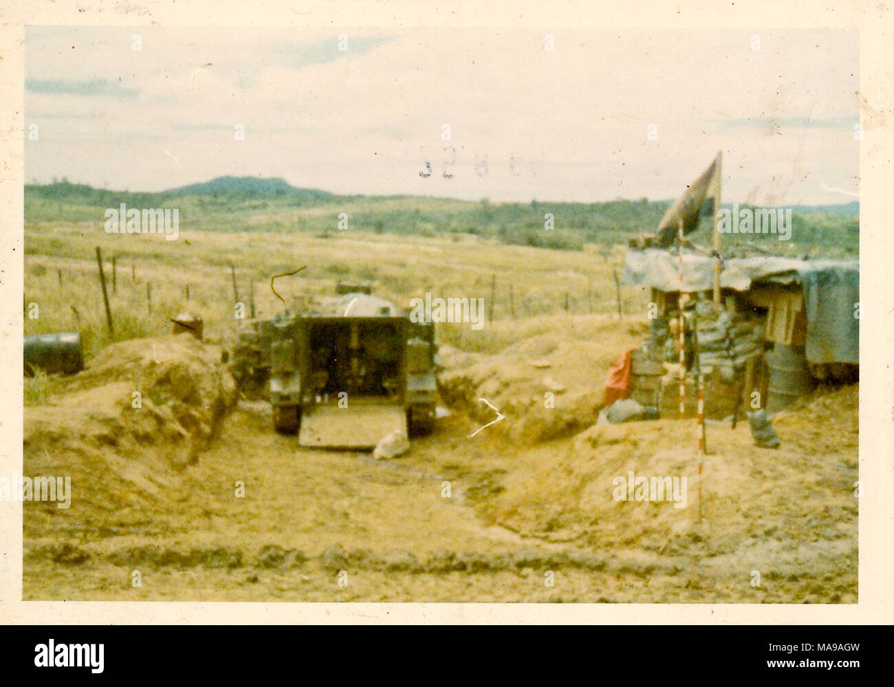 Fotografia a colori di un veicolo militare, con un temporaneo rifugio a destra, in un paesaggio erboso, fotografato in Vietnam durante la Guerra del Vietnam (1955-1975), 1971. () Foto Stock