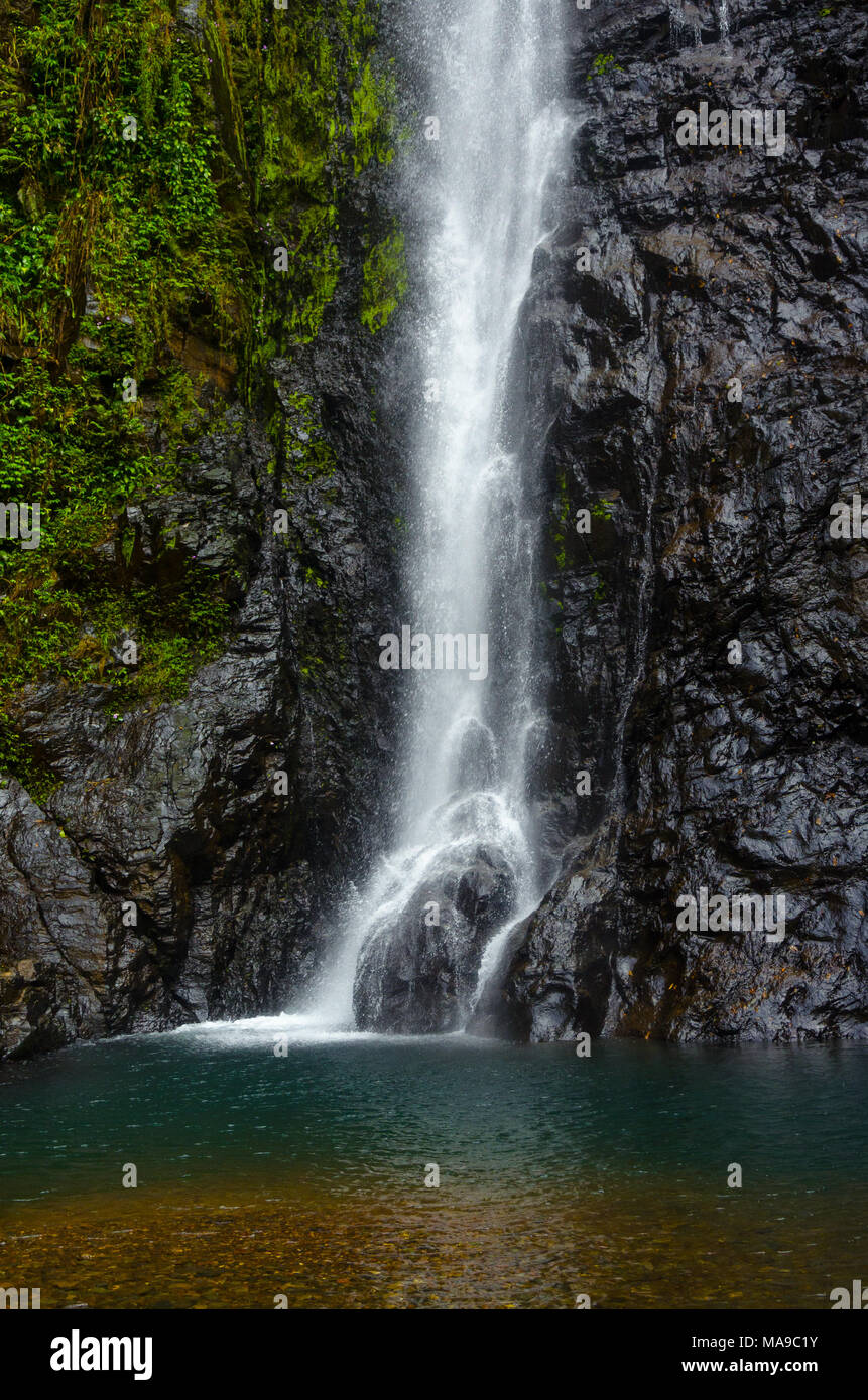 Bella, rinfrescante vista di acqua in caduta da altezza e schizzi su roccia alla base della cascata Mainapi, Netravali Wildlife Sanctuary, Goa. Foto Stock