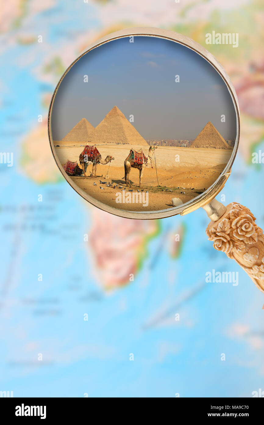 Guardando in su le piramidi di Egitto a Giza attraverso una lente di ingrandimento su un atlante mappa Africa Foto Stock