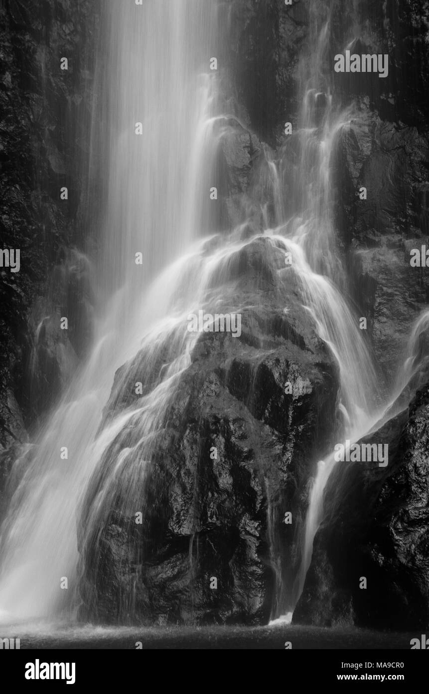 Bella, rinfrescanti, nero e sfondo bianco di acqua in caduta da altezza, schizzi su roccia. Foto Stock