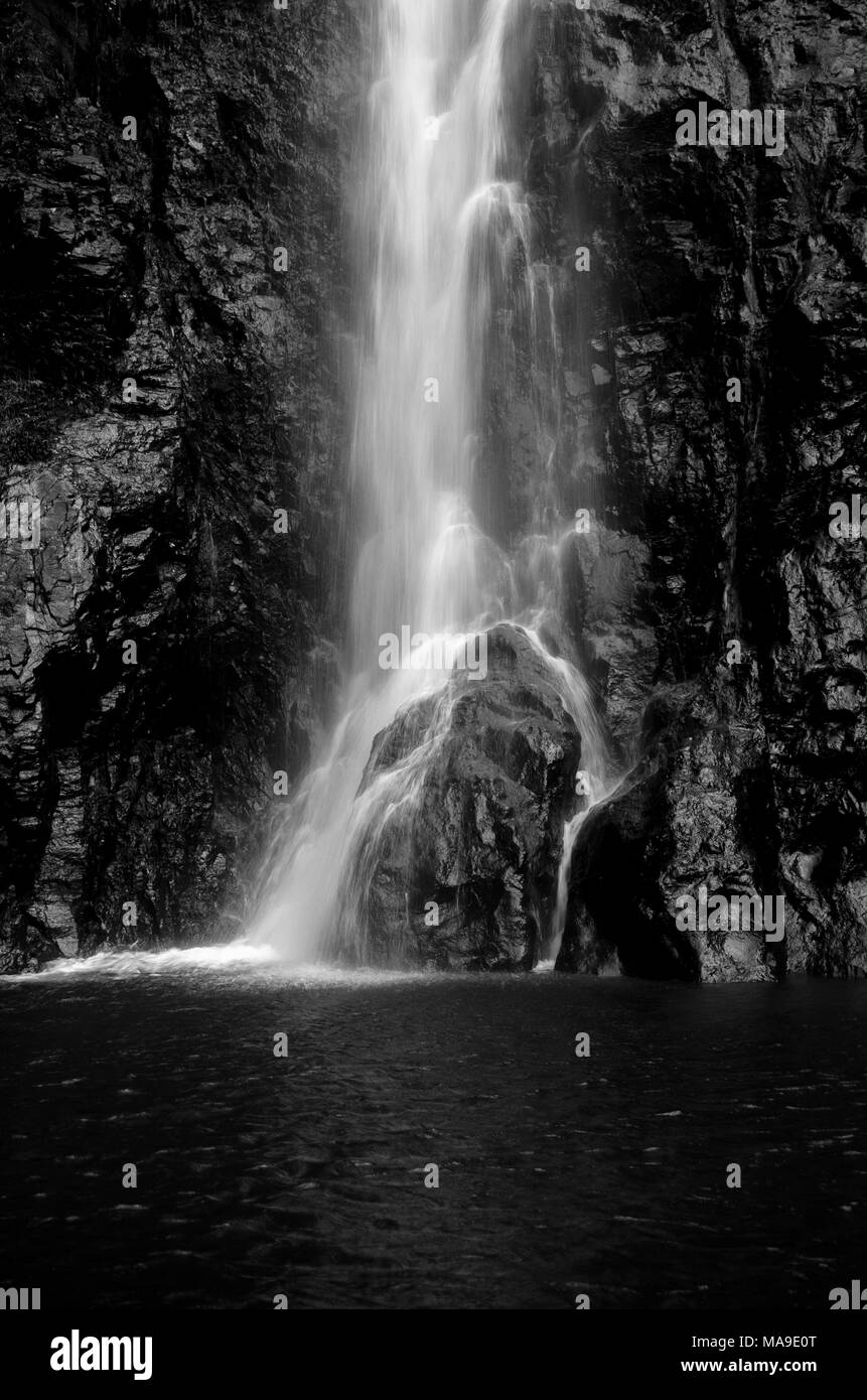 Bella, rinfrescanti, immagine in bianco e nero di acqua in caduta da altezza, schizzi su roccia. Foto Stock