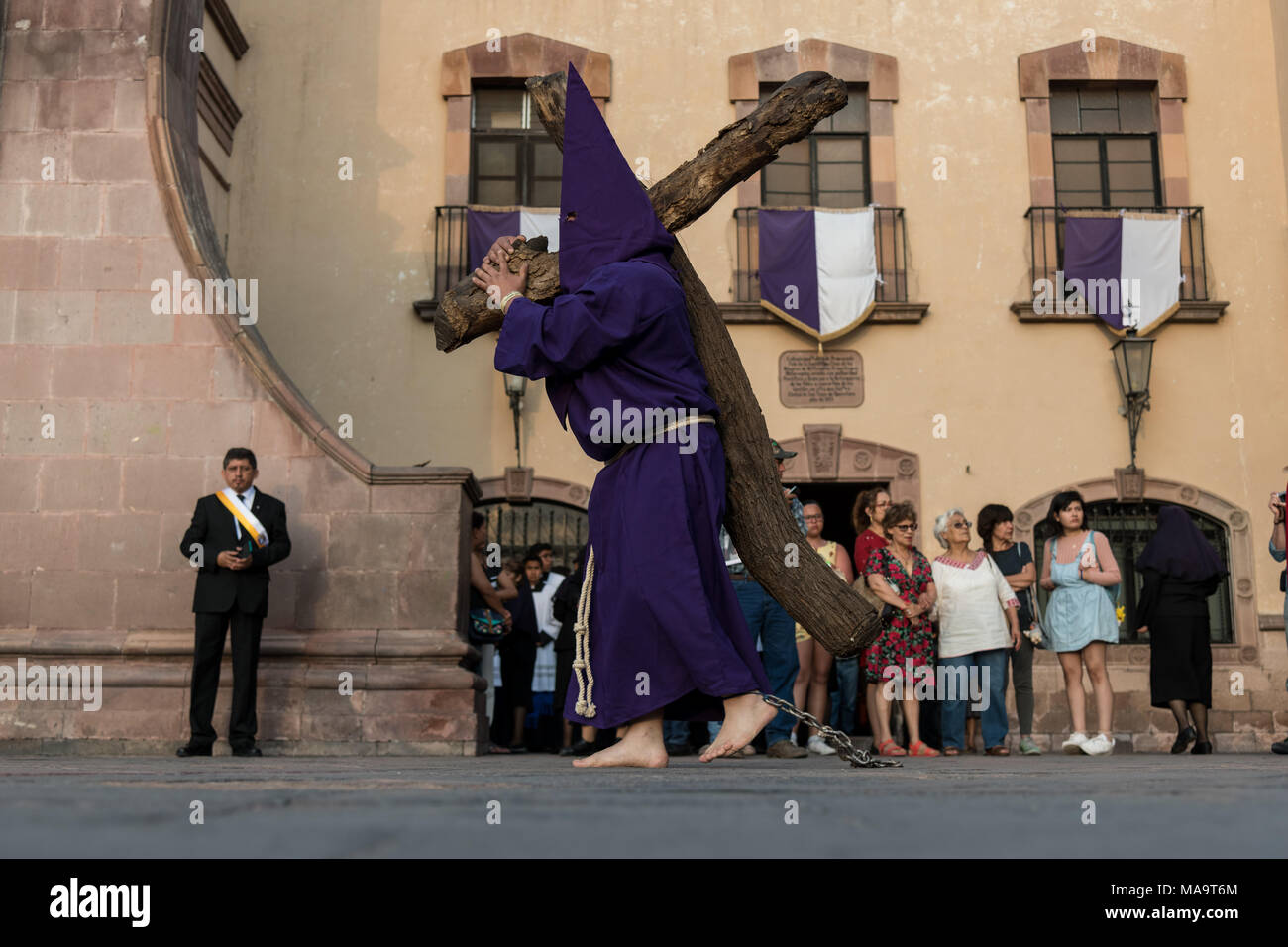 Queretaro, Messico, 31 Mar 2018. I penitenti incappucciati portano croci di legno come iniziano la processione del silenzio attraverso le strade della città il Venerdì Santo durante la Settimana Santa, Marzo 30, 2018 a Querétaro, Messico. I penitenti, noto come Nazareni, portano i pesanti croci e delle catene di resistenza in quattro ore di marzo in memoria della passione di Cristo. Credito: Planetpix/Alamy Live News Foto Stock