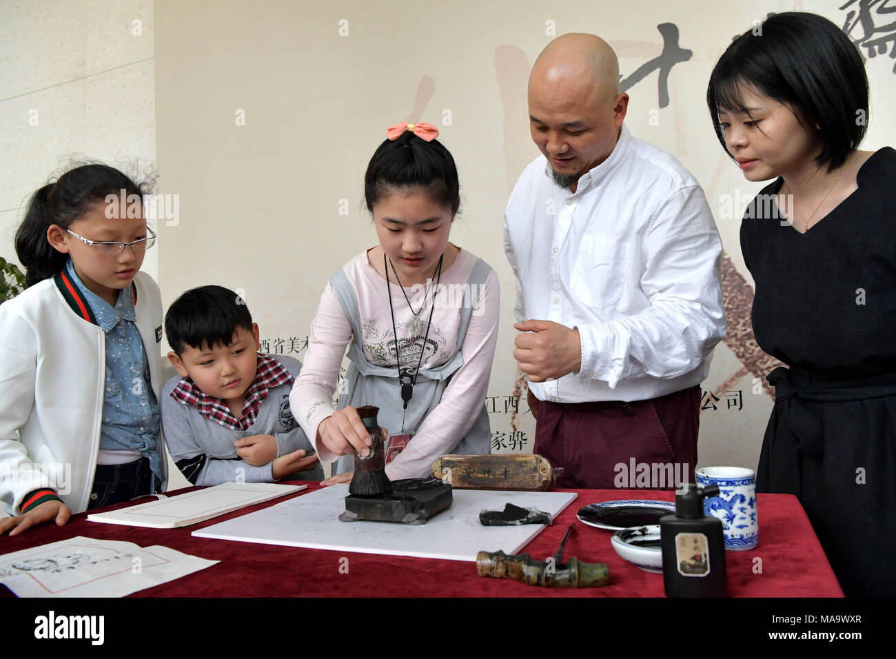 Nanchang, cinese della provincia di Jiangxi. 31 Mar, 2018. Wei Lizhong (2R), erede di cinesi woodblock tecnica di stampa, insegna a un breve corso sulla woodblock stampa durante una mostra presso il Museo Provinciale d'arte di Nanchang, Cina orientale della provincia di Jiangxi, Marzo 31, 2018. Oltre 100 pezzi di woodblock printing works sono stati esposti nella mostra. Credito: Peng Zhaozhi/Xinhua/Alamy Live News Foto Stock