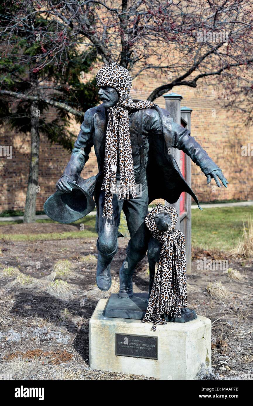 Aurora, Illinois, Stati Uniti d'America. Una statua dedicata a Aurora vigili del fuoco adornata con un cappello e una sciarpa durante l inverno al regionale Aurora Fire Museum. Foto Stock