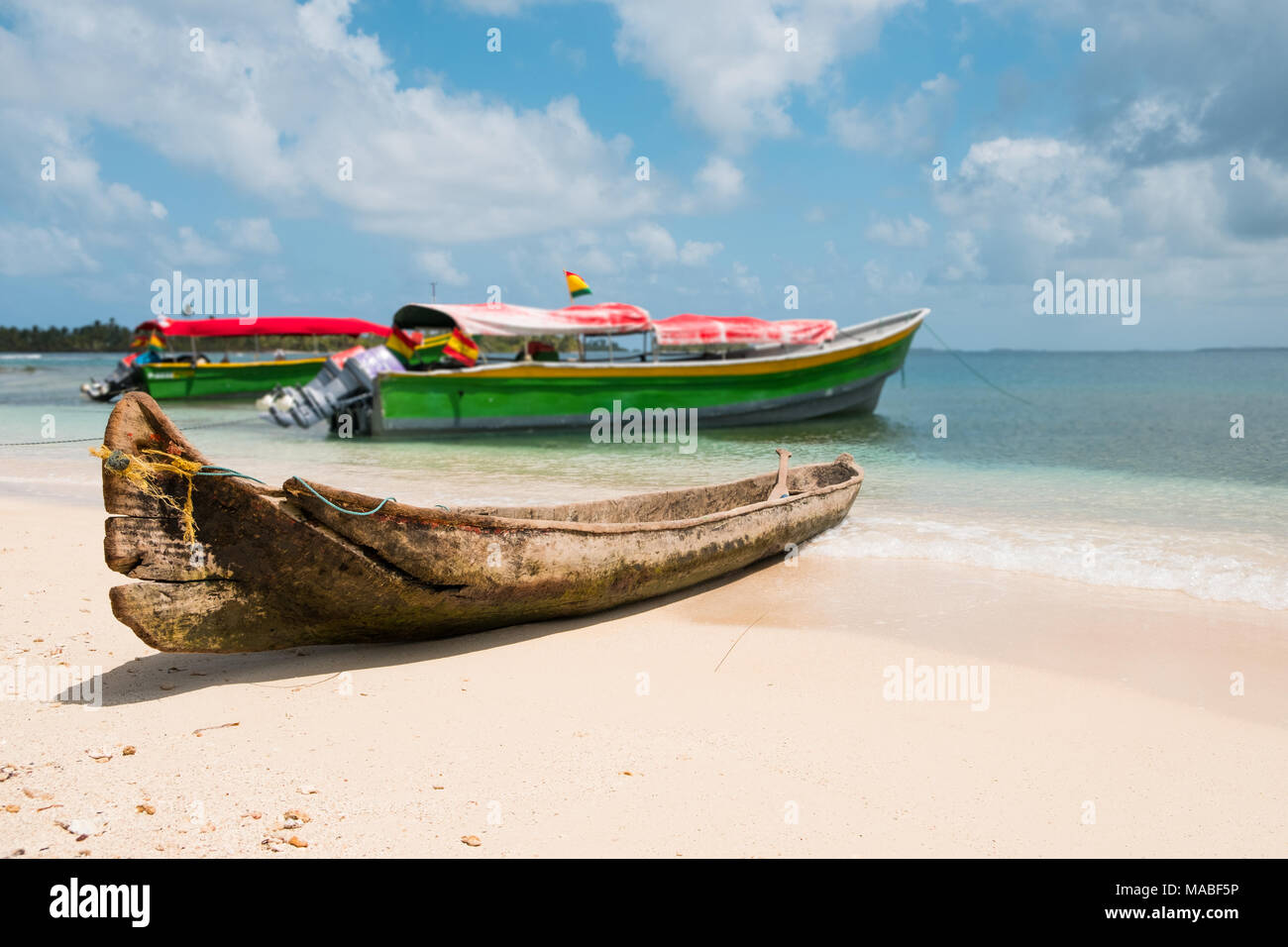 Vecchio canoe di legno barca e barche a motore sulla spiaggia, Guna Yala, Panama Foto Stock