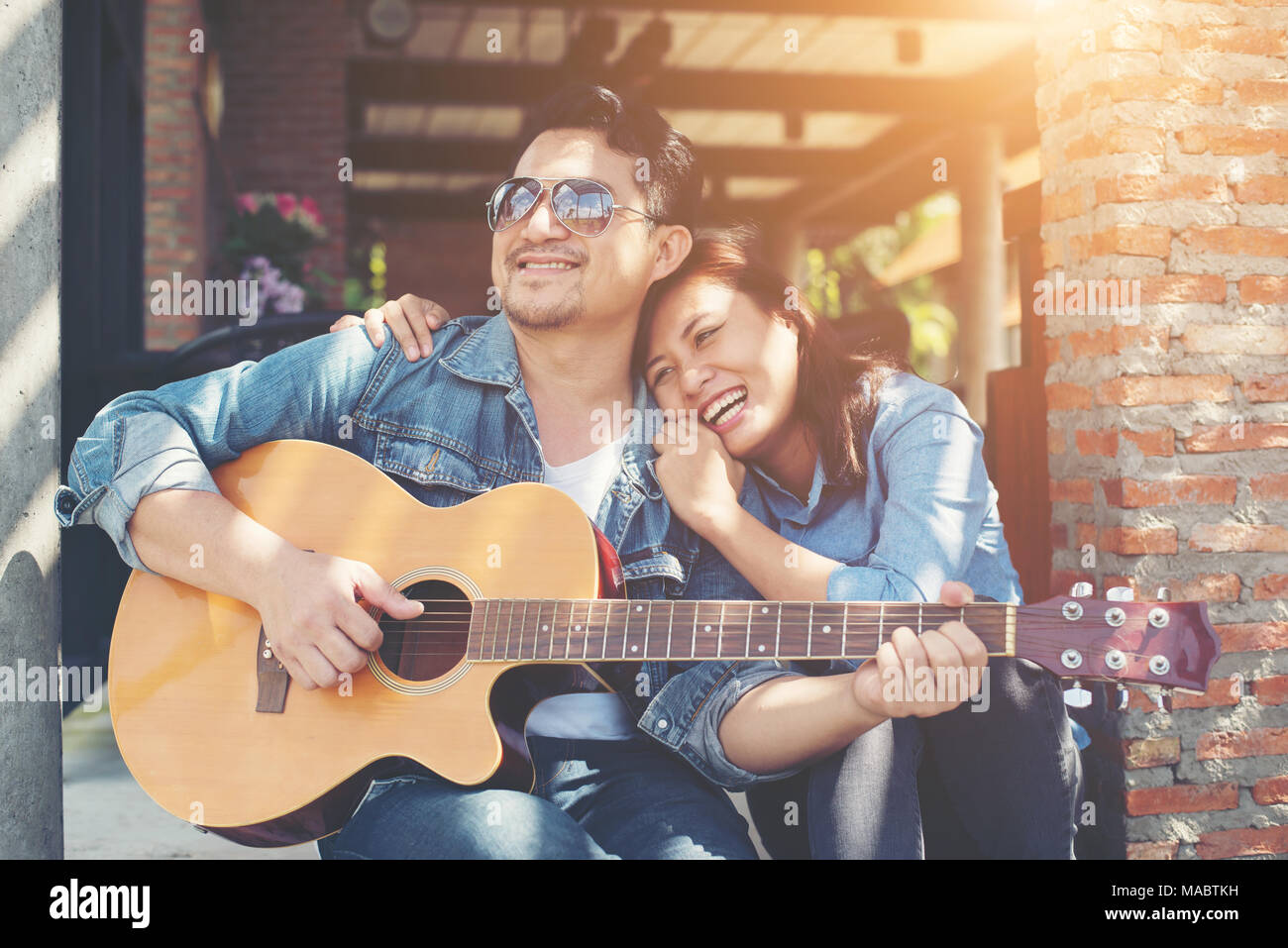 Hipster giovane seduti rilassati con una bella atmosfera con la prima data gode di suonare la chitarra come un grande tempo insieme. Foto Stock