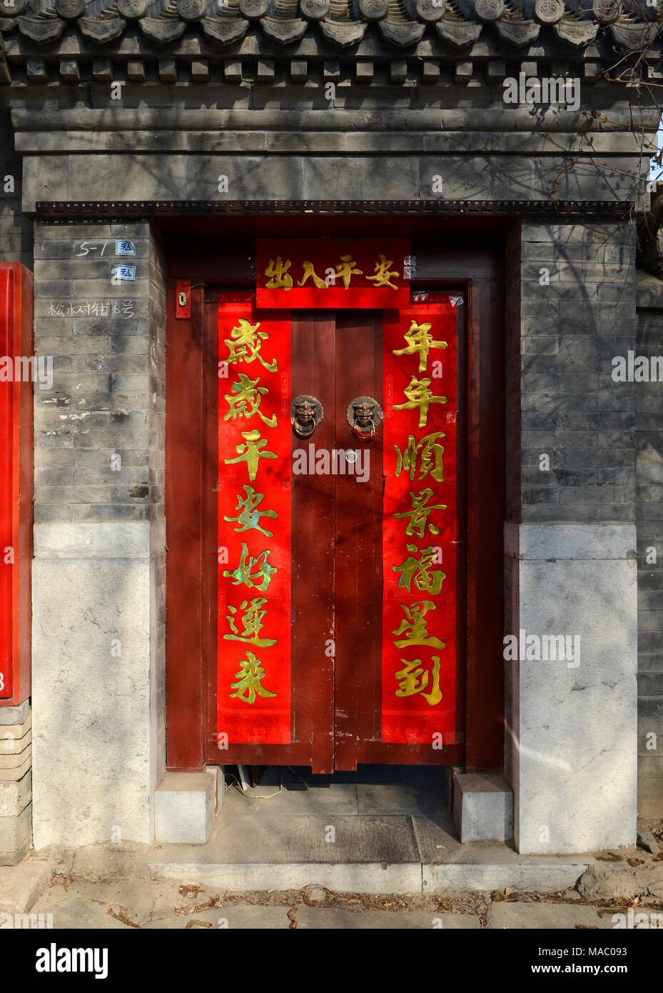 Baciata sulla porta di una tradizionale casa cortile in un hutong vicino l'Houhai nel nord centrale di Pechino, Cina, diamo il benvenuto al nuovo anno lunare Foto Stock