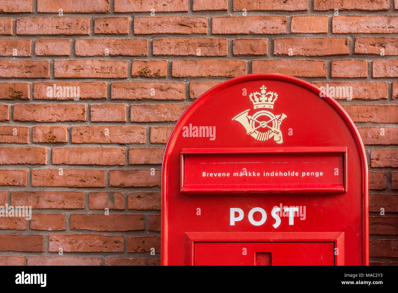 Un rosso postbox danese su un muro di mattoni, Danimarca, 30 mars 2018 Foto Stock