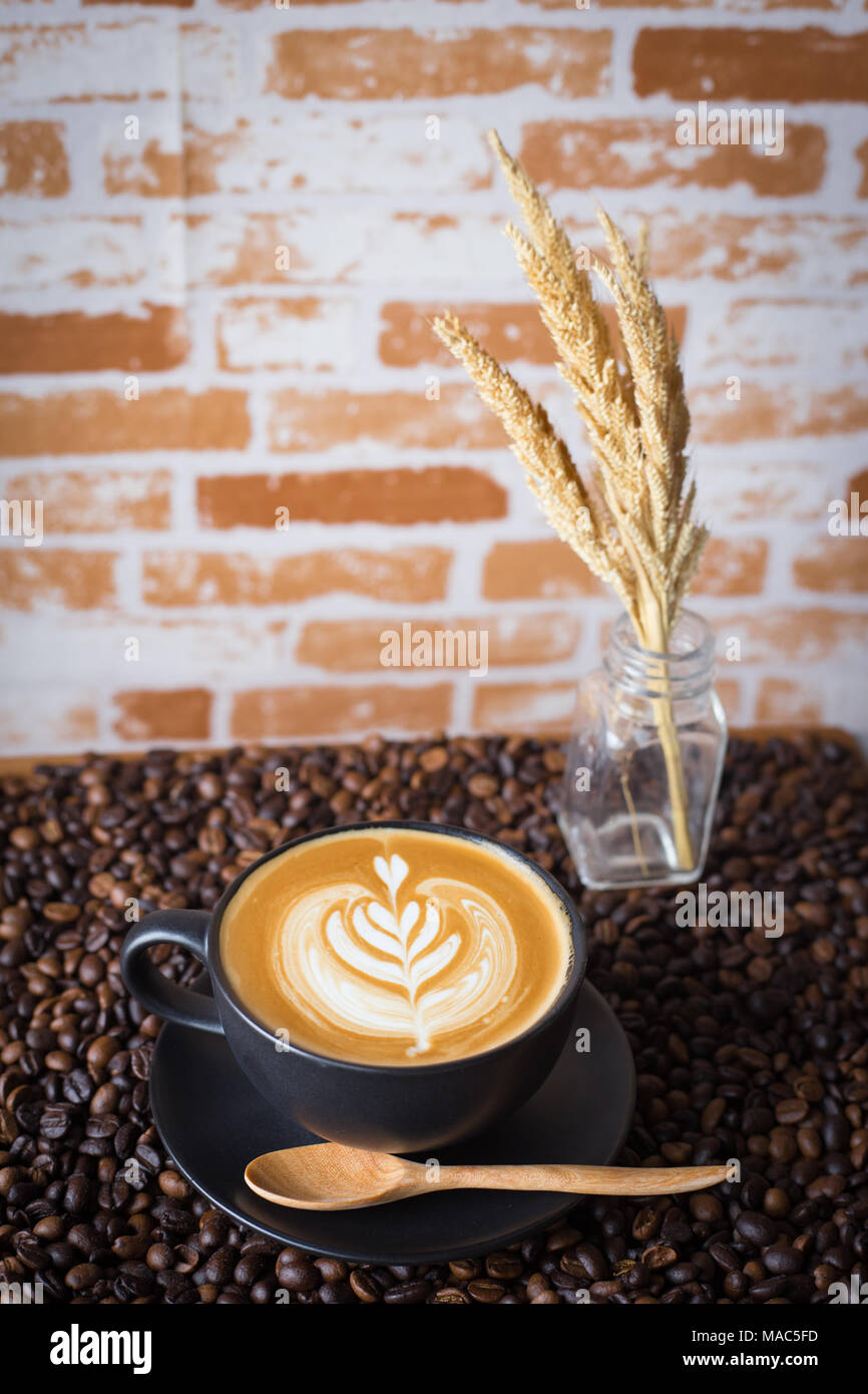 Latte art caffè sopra a chicchi di caffè sfondo Foto Stock