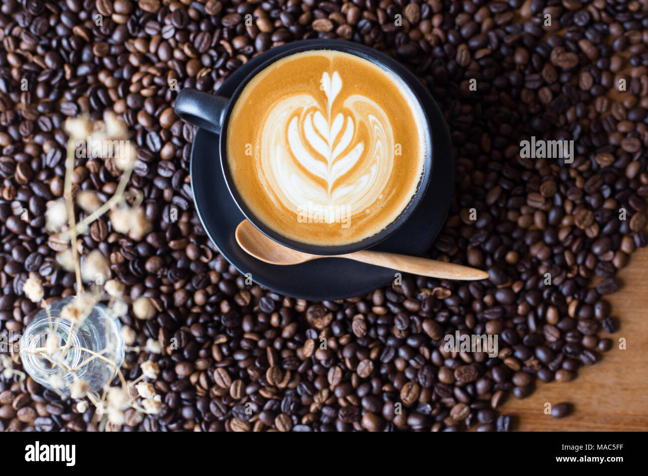 Latte art caffè sopra a chicchi di caffè sfondo Foto Stock