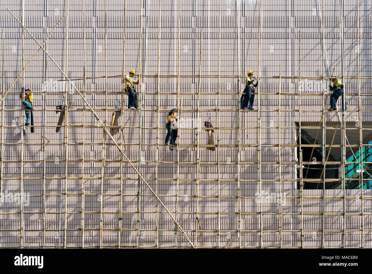 Lavoratori edili sui ponteggi al di fuori di una nuova costruzione, Hong Kong, Cina Foto Stock