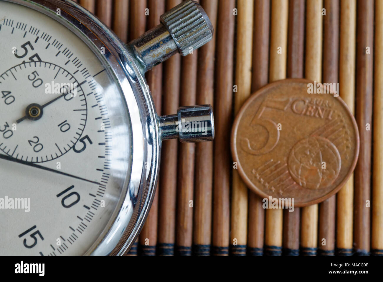 Cronometro e moneta con un valore nominale unitario di 5 centesimi di euro  sul tavolo di legno sfondo Foto stock - Alamy