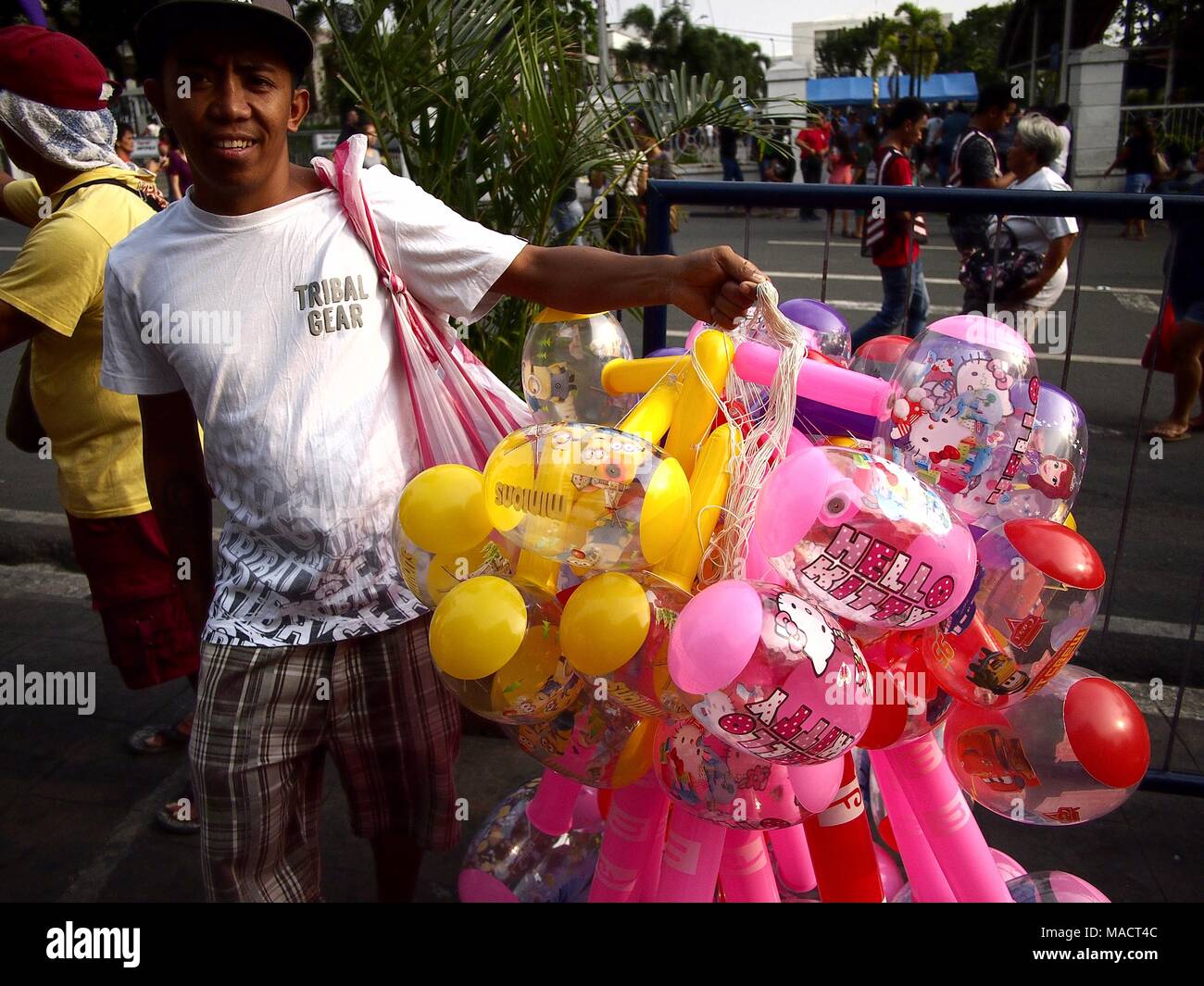 ANTIPOLO City, Filippine - 29 Marzo 2018: un venditore ambulante vende colorato dei giocattoli gonfiabili. Foto Stock