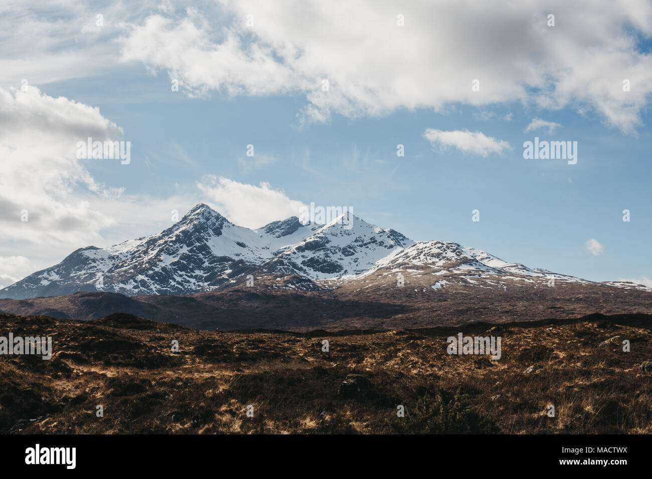 Vista del paesaggio delle Highlands scozzesi, Scozia, nuvoloso cielo blu e delle montagne innevate sullo sfondo. Foto Stock