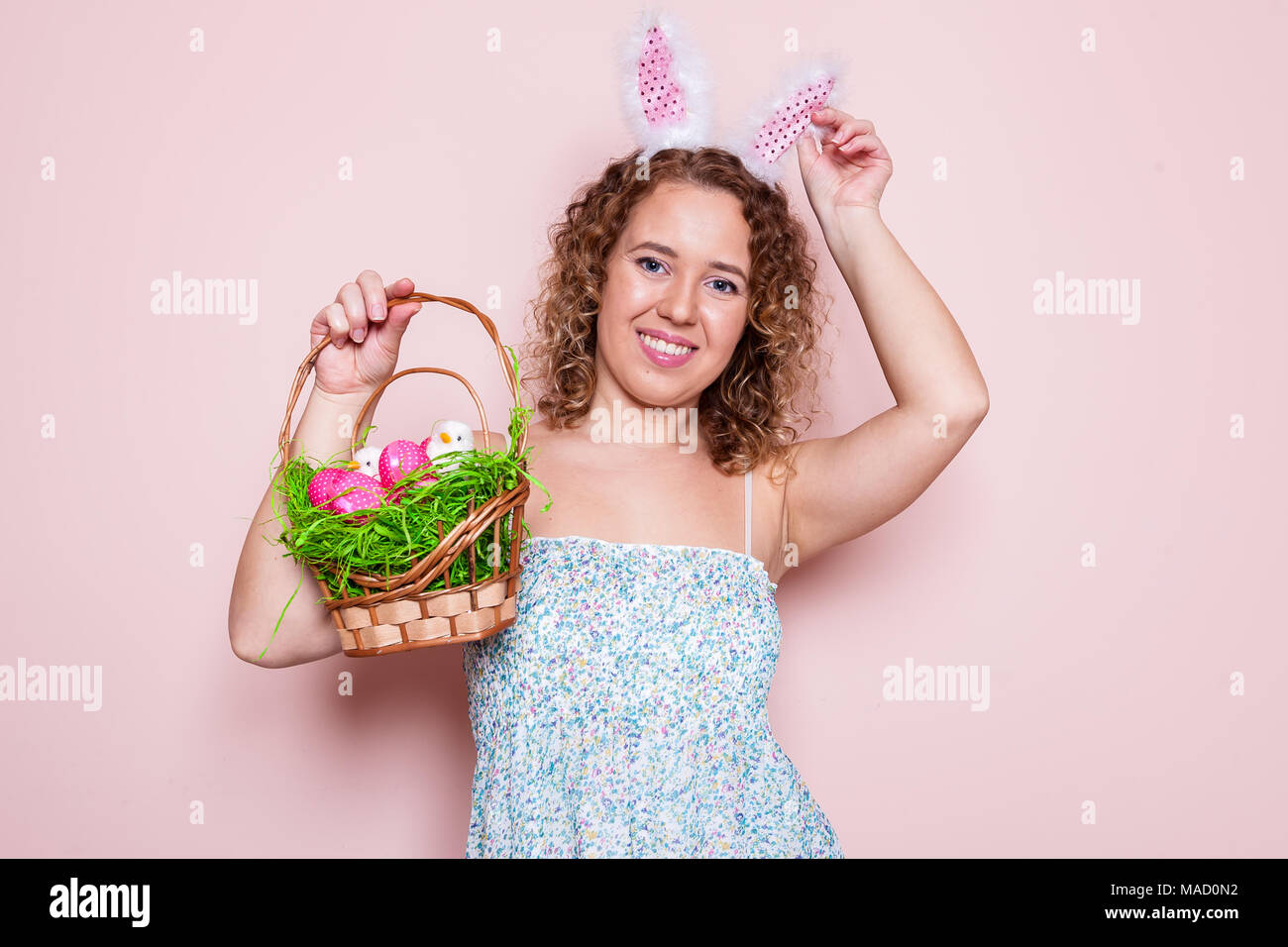 Bella donna tenere decorazioni di pasqua con orecchie di coniglietto rosa su sfondo colorato con copia spazio. Foto Stock