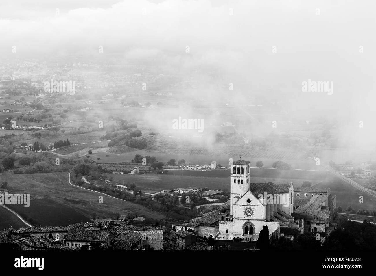 Vista di San Francesco chiesa papale in Assisi (Umbria, Italia) nel mezzo di sollevamento di nebbia di mattina Foto Stock